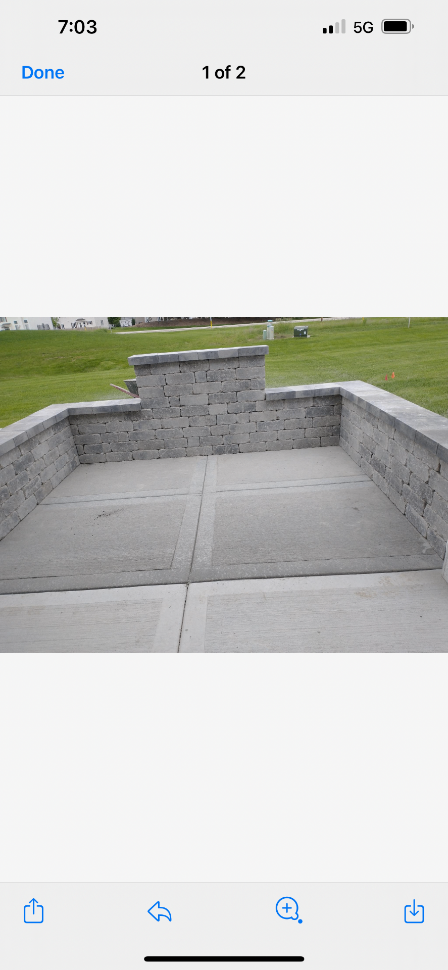 Freestanding stone masonry wall with capstones in a backyard