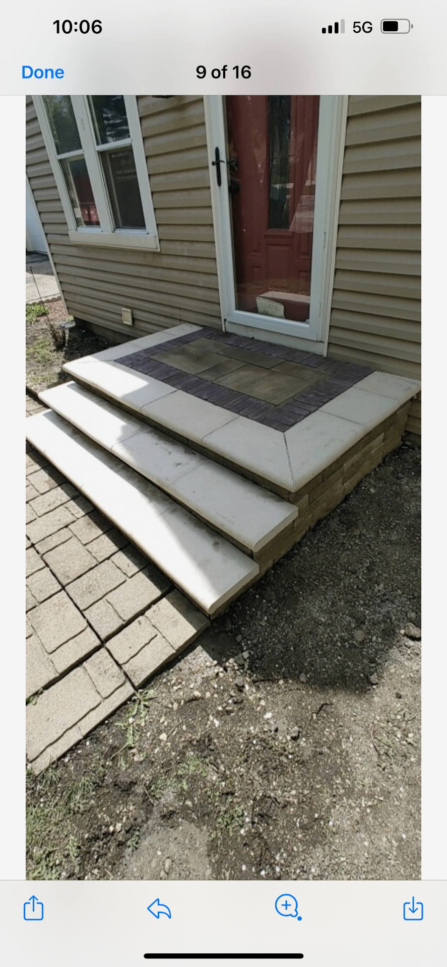 Front entry stoop with wide stone steps and paver inlay landing